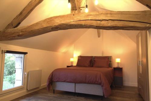 Parnay的住宿－Gîte 21 route de saumur，一间卧室设有一张带木制天花板的大床