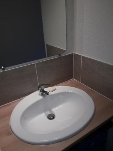 un lavabo blanc dans une salle de bain avec un miroir dans l'établissement Studio 007 à Aix, à Aix-en-Provence