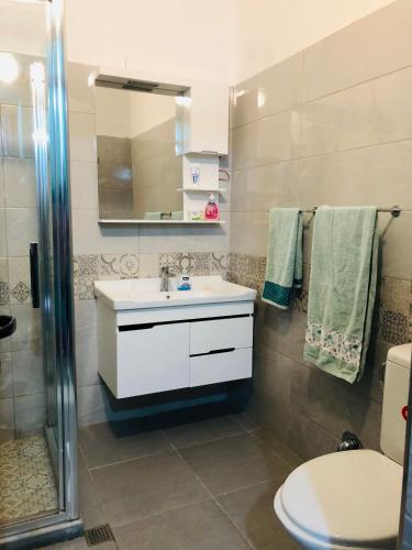 a bathroom with a sink and a toilet and a mirror at SALA Apartments in Velipojë