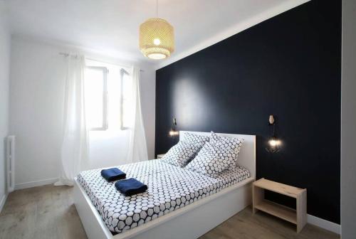 a bedroom with a white bed with a black wall at Magnifique 3 pièces Garibaldi in Nice