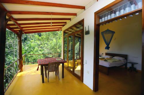 a room with a balcony with a table and a bed at Nine Arch View Ella in Ella