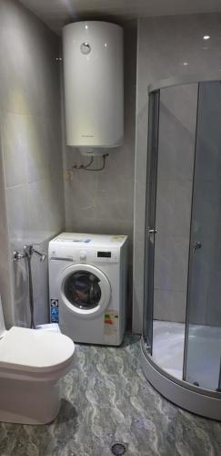 Un baño con lavadora y un inodoro. en ApartHotel Calypso in Orbi, en Batumi