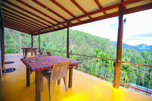 a table and chairs on a balcony with a view at Nine Arch View Ella in Ella