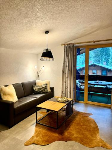a living room with a couch and a table at K-Appartements Klösterle in Klösterle am Arlberg