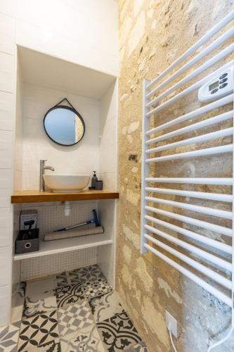 une salle de bain avec un lavabo et un miroir dans l'établissement Flore, à Saint-Aignan