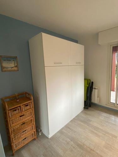 een grote witte kast in de hoek van een kamer bij Le Petit Nid du Port Crouesty - Studio au calme in Arzon