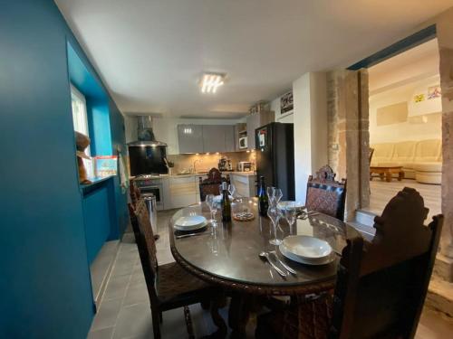a dining room table with chairs and a kitchen at Au Lavoir in Vinzelles
