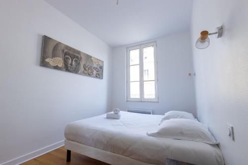 um quarto branco com uma cama e uma janela em Le Grand Bilobou em Noyers-sur-Cher