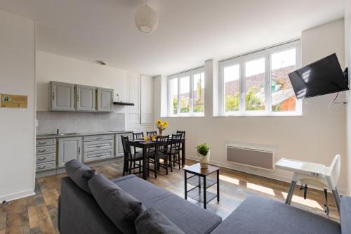 uma sala de estar e cozinha com um sofá e uma mesa em Le Grand Bilobou em Noyers-sur-Cher