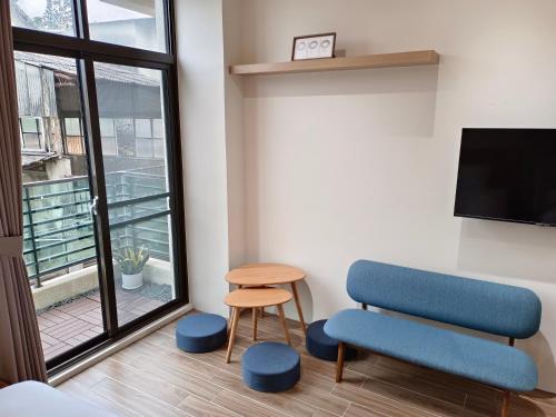a room with a chair and a tv and a stool at 日日和 in Tainan