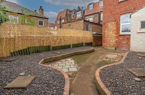 a backyard with a fence and a stone pathway at 2 Bed Garden Flat at Primal Estates Short Lets in Brighton in Brighton & Hove