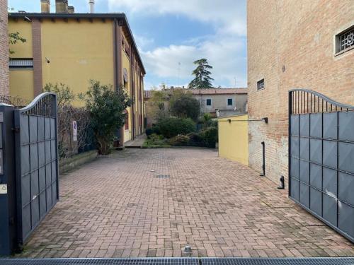 an empty courtyard with a gate and a brick building at Interno 8 appartamento con box auto privato gratuito in Ferrara