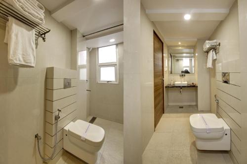 a bathroom with a toilet and a sink at Hotel Shanti Plaza-by Haveliya Hotels in New Delhi