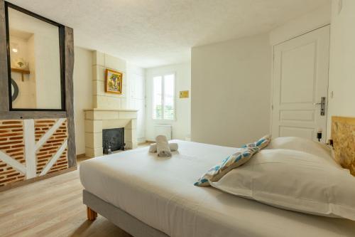 um quarto com uma cama grande e uma lareira em Faune em Saint-Aignan