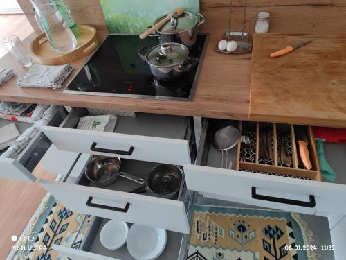 a kitchen with an open drawer with pots and pans at Wohnung mit Weitblick in Schwäbisch Hall