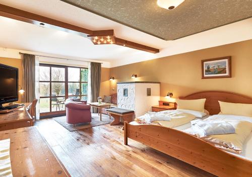 a large bedroom with a large bed and a television at Wellnesshotel Riedlberg in Drachselsried