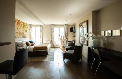 salon z łóżkiem i kanapą w obiekcie VILLA FLEURY - APPART'HÔTEL DE STANDING w mieście Limoges
