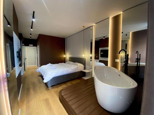 a bedroom with a bed and a bath tub at Capital Suites Center in Tirana