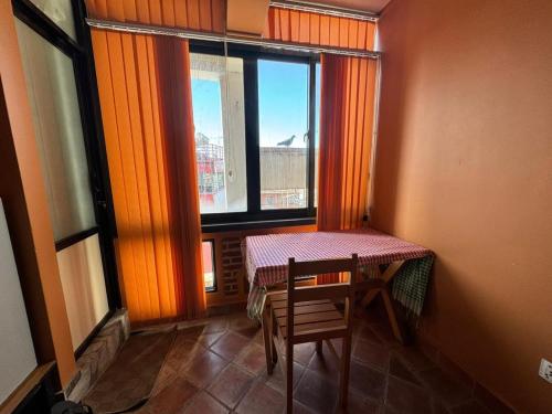 una mesa y una silla en una habitación con ventana en loo niva guest house studio apartment with balcony, en Pātan