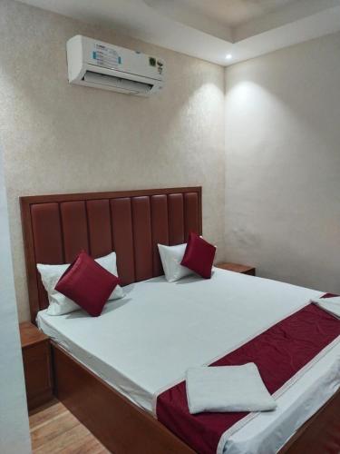 a bedroom with a large bed with red and white pillows at Pyrenees Homestay in Agra