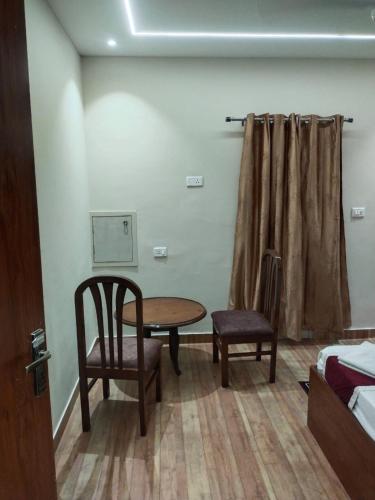a room with a table and a chair and a bed at Pyrenees Homestay in Agra