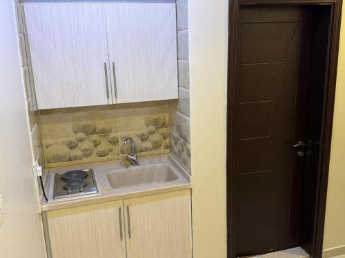 una pequeña cocina con fregadero y encimera en PRIMOTEL Suites As Salamah en Yeda