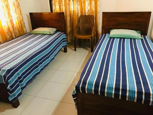 duas camas sentadas uma ao lado da outra num quarto em BATTI REST em Batticaloa