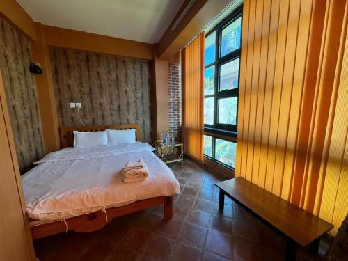 um quarto com uma cama e uma grande janela em loo niva guest house studio apartment with balcony em Patan