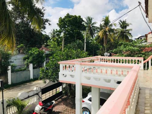 einen rosa Balkon eines Hauses mit einem Roller in der Unterkunft BATTI REST in Batticaloa