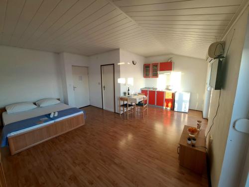 Un dormitorio con una cama y una cocina con una mesa. en Apartments Maruna, en Maslenica