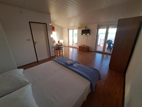 una grande camera con un letto e un soggiorno di Apartments Maruna a Maslenica