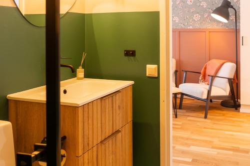 a bathroom with a sink and a green wall at Glaskogen Apartments in Glava