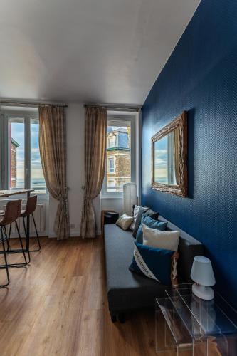 un salon bleu avec un canapé et une table dans l'établissement Appartement Saint-Malo - Vue mer, à Saint-Malo