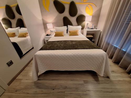 a hotel room with two beds and a mirror at Hotel Aleluia in Fátima