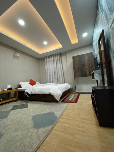 a bedroom with a bed and a tv in a room at Yul Pemakhar in Tawang