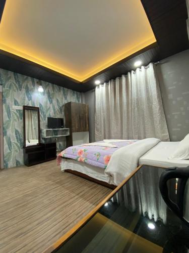 a bedroom with a bed and a desk and a mirror at Yul Pemakhar in Tawang