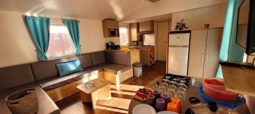 a living room with a couch and a kitchen at Camping Aux Portes De Cassis in La Bédoule
