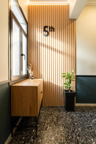 an office with a wooden wall with a clock on it at PAME House in Athens