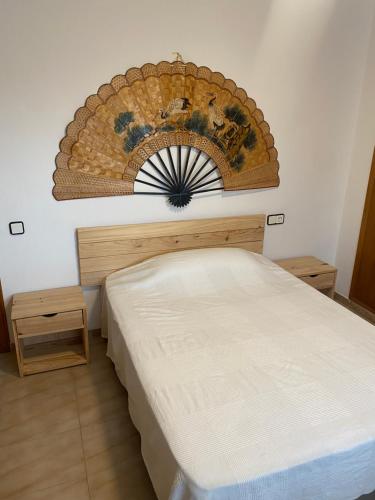 a bedroom with a bed and a wreath on the wall at Apartamento para 8 sobre el mar in Salou