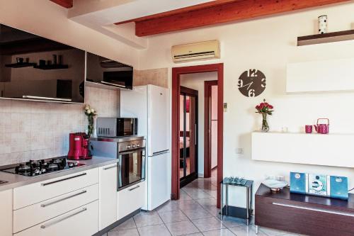 a kitchen with white cabinets and a stove at Casa Azzurra in San Sperate