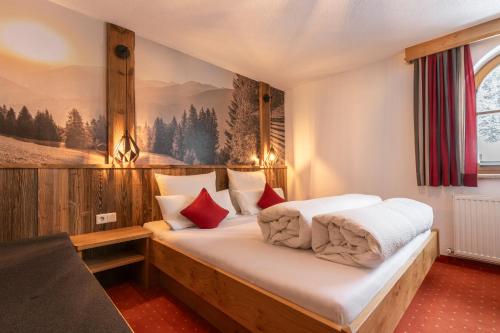 カウナータールにあるApart WiesenPlatzlのベッドルーム1室(白いシーツと赤い枕のベッド1台付)
