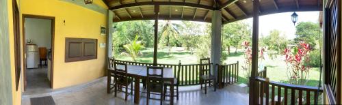 a room with a table and chairs on a balcony at Villa De Lagoon View in Tangalle