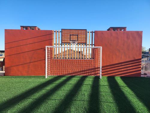 un aro de baloncesto al lado de un edificio en El 5to Elemento en La Falda