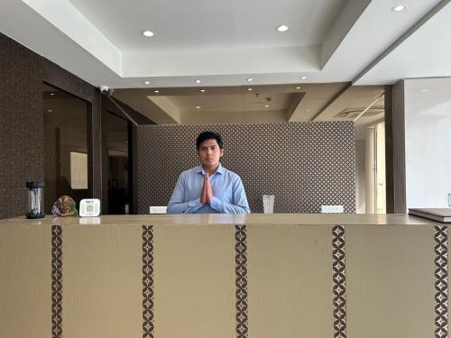 a man sitting at a counter in an office at Hotel President Agra near Taj mahal in Agra