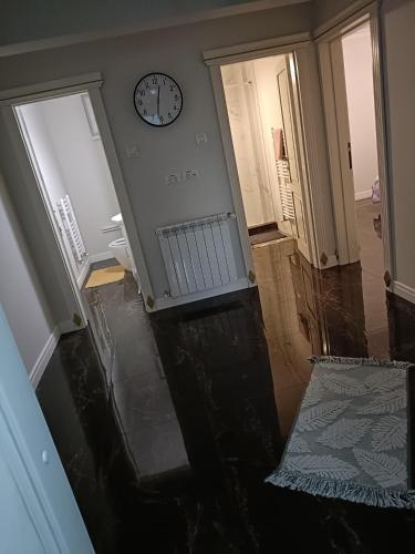 un couloir vide avec une horloge sur le mur dans l'établissement Residence Manu Targu Neamt, à Tîrgu Neamţ