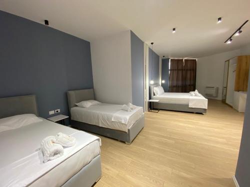 a hotel room with two beds and a bathroom at Capital Suites Center in Tirana