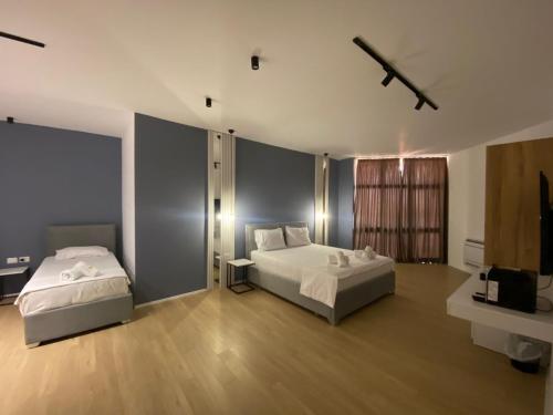a hotel room with two beds and a television at Capital Suites Center in Tirana