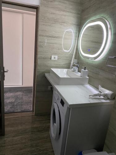 a bathroom with a sink and a washing machine at Serin Blaxy Studio in Mangalia