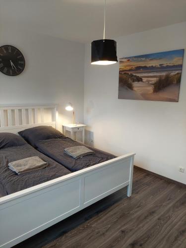 a bedroom with a bed with a clock on the wall at Lech Appartement in Landsberg am Lech