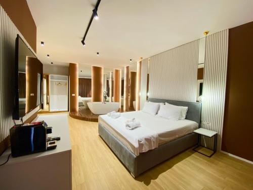 a bedroom with a large bed and a bathroom at Capital Suites Center in Tirana